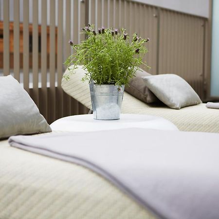 فندق ستيجنبرجر آم كانزليرمت برلين الغرفة الصورة The photo shows two lounge chairs with soft, light-colored cushions. Between them, there is a small round table featuring a metal bucket filled with greenery. The setting appears to be designed for relaxation, with a clean and modern aesthetic, likel